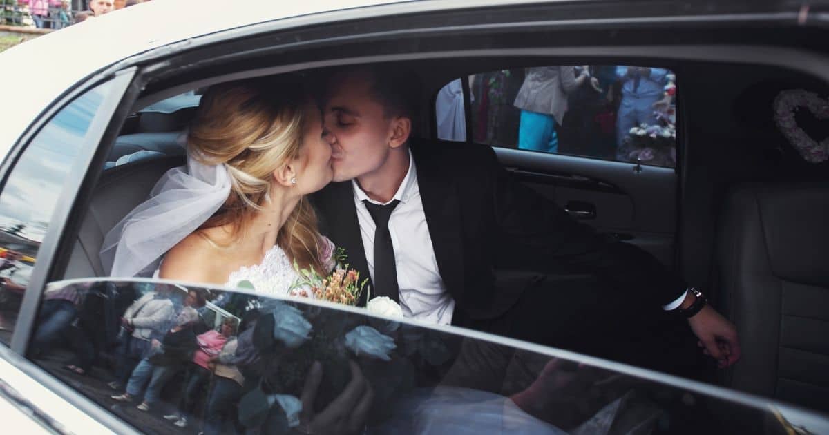 Newlyweds kissing in a white limo